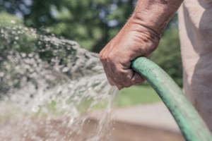 a person holding a hose with spraying water